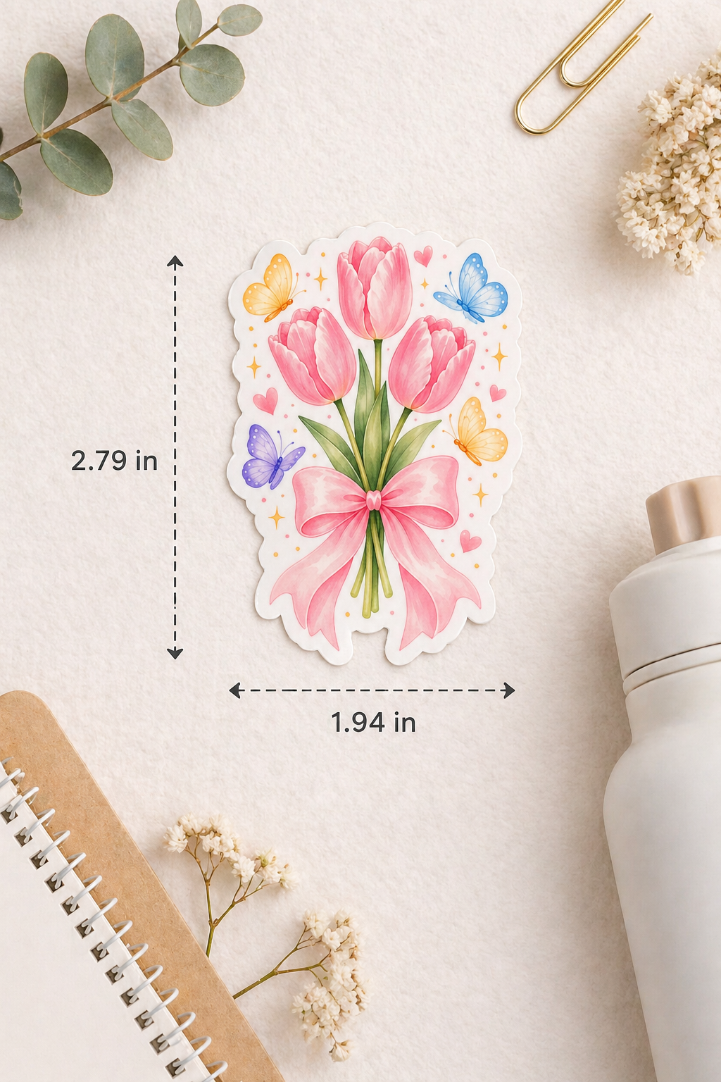 Floral sticker with measurements on a light surface with stationery items